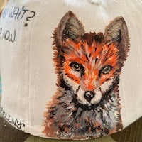 a hat with a painting of a fox on it